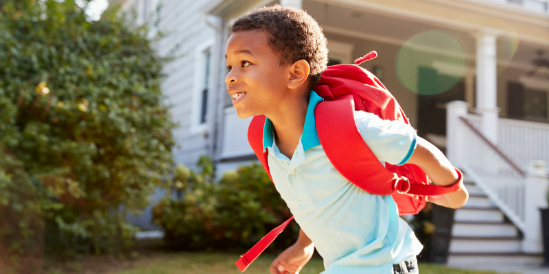 Child wearing a backpack running