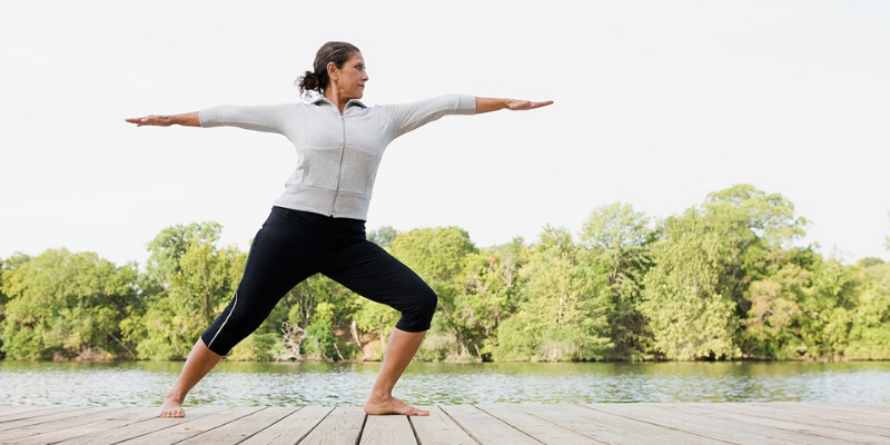 Person in athletic gear doing yoga on a dock